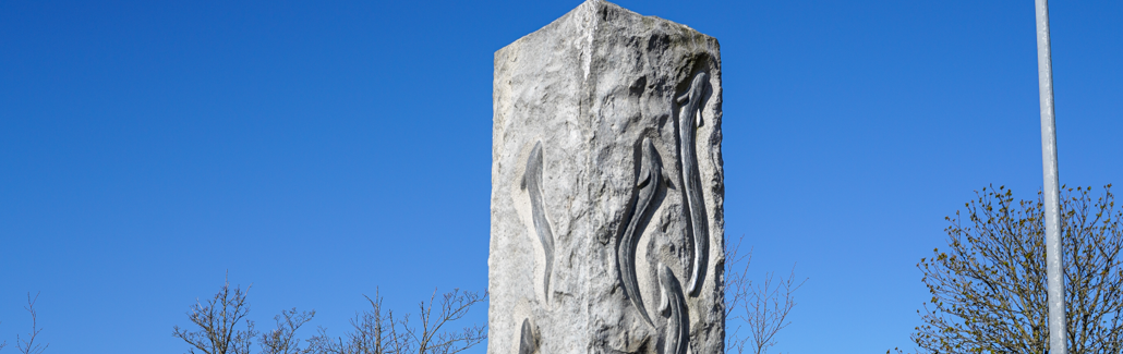 Høj firkantet granitsøjle med ål på siden