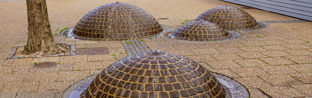 Halve runder kugler med brosten der stikker op af jorden