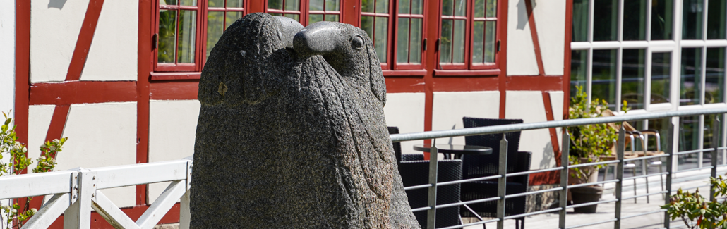 Granitsskulptur med dyr i omfavnelse