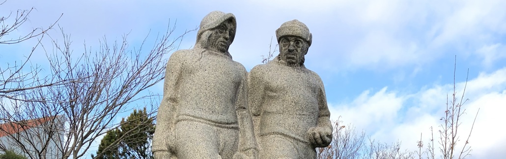 To fiskere i granit på firkantet sokkel