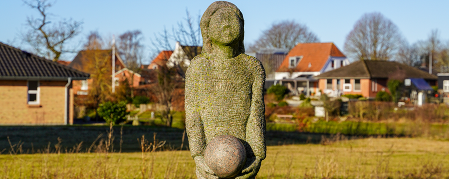 Pige med bold i hænderne i granit