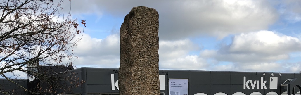 Brunlig stensøjle med indgraveret skrift