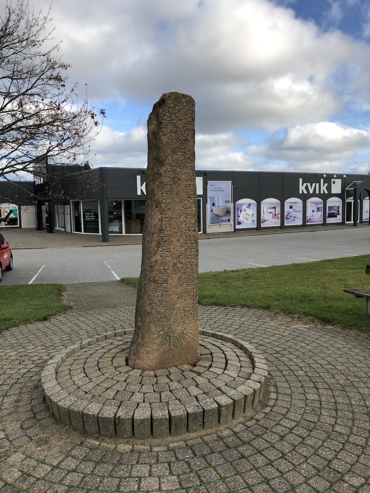 Brunlig stensøjle med indgraveret skrift