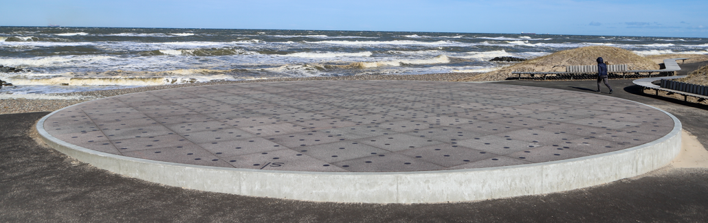 Stor granitcirkel med små runde metalpletter