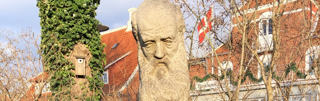 Stenbuste af skaldet mand med stort skæg