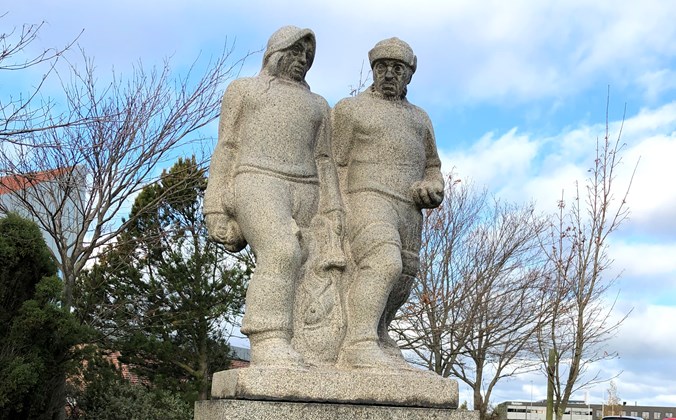 To fiskere i granit på firkantet sokkel