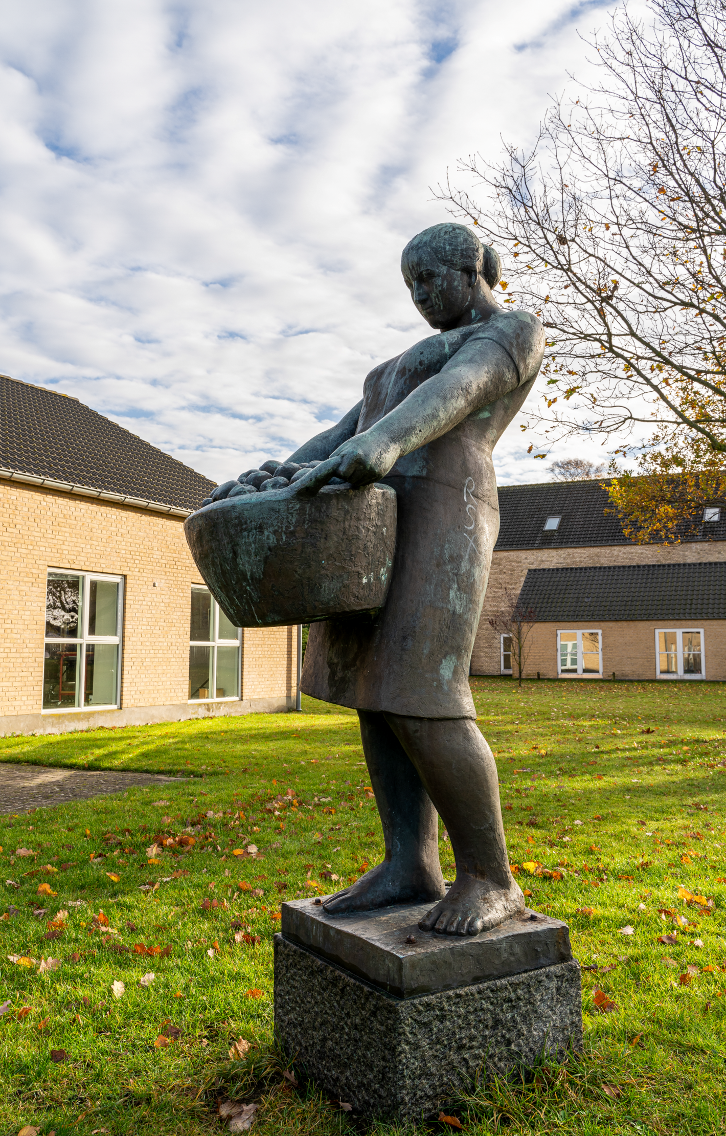 Bronzeskulptur af kvinde med en kurv æbler