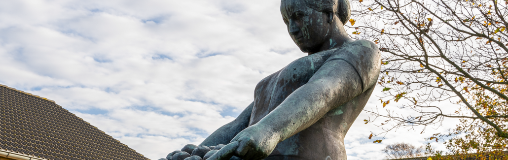 Bronzeskulptur af kvinde med en kurv æbler
