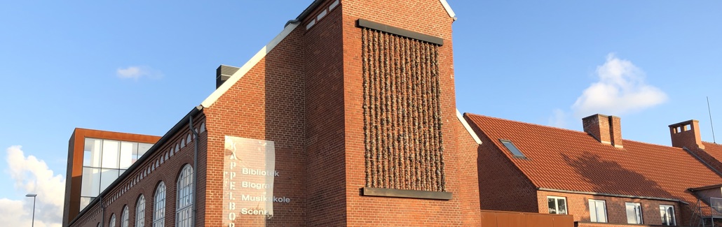 Stort relief af sten der hænger på husgavl