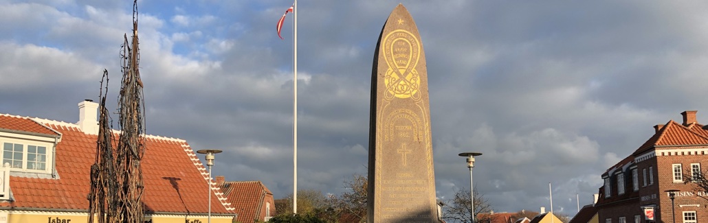 Høj brunlig mindesten med guldskrift
