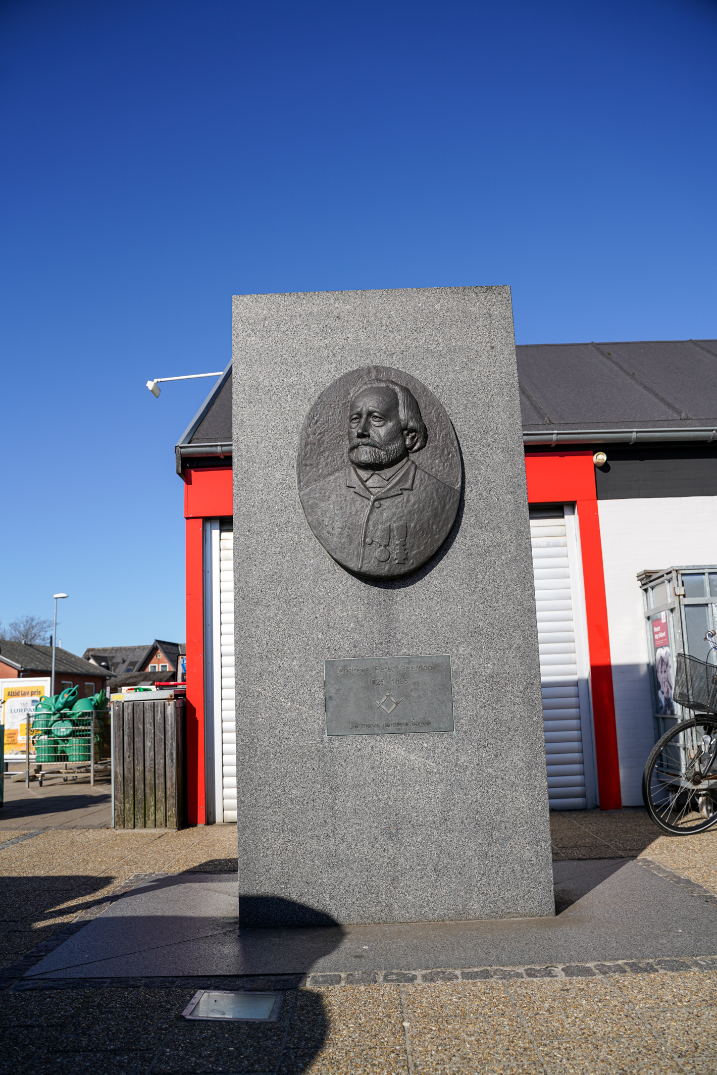 Grå firkantet stenplade med billede af mand 