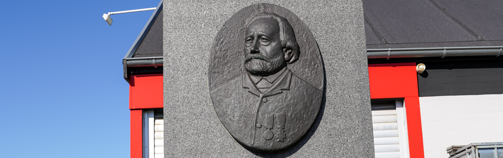 Grå firkantet stenplade med billede af mand