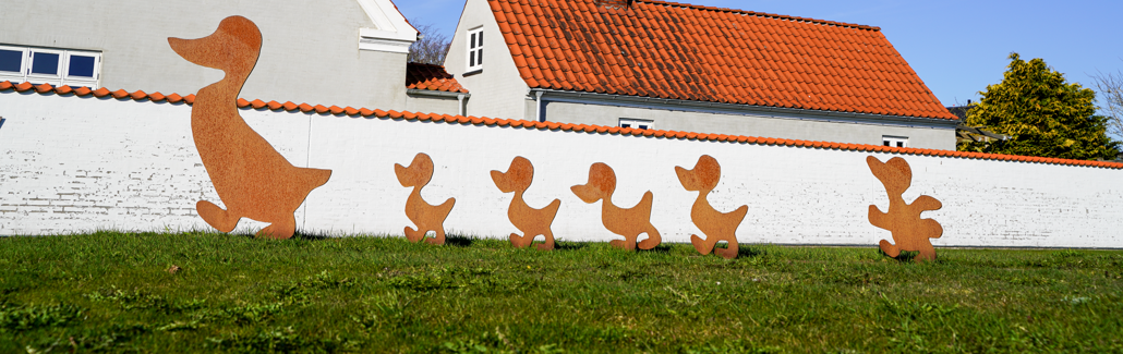 Gående andemor med sine fem ellinger i metal