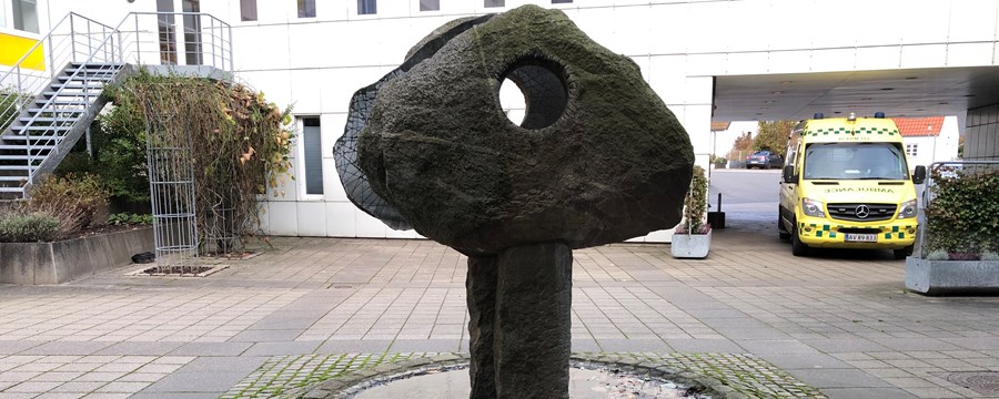 Stor granitsten med hul igennem stående på søjle