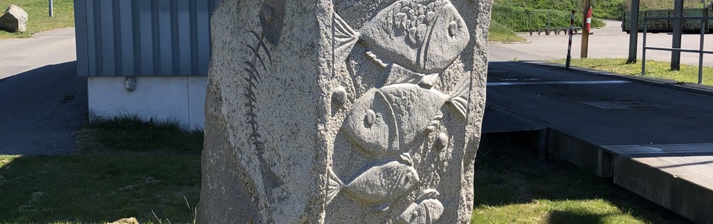 Granitsøjle med fiskefigurer