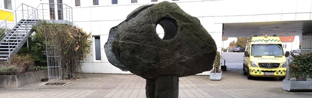 Stor granitsten med hul igennem stående på søjle