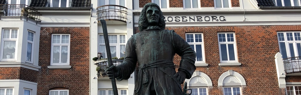 Bronzestatue af Tordenskjold med gevær på granitsokkel