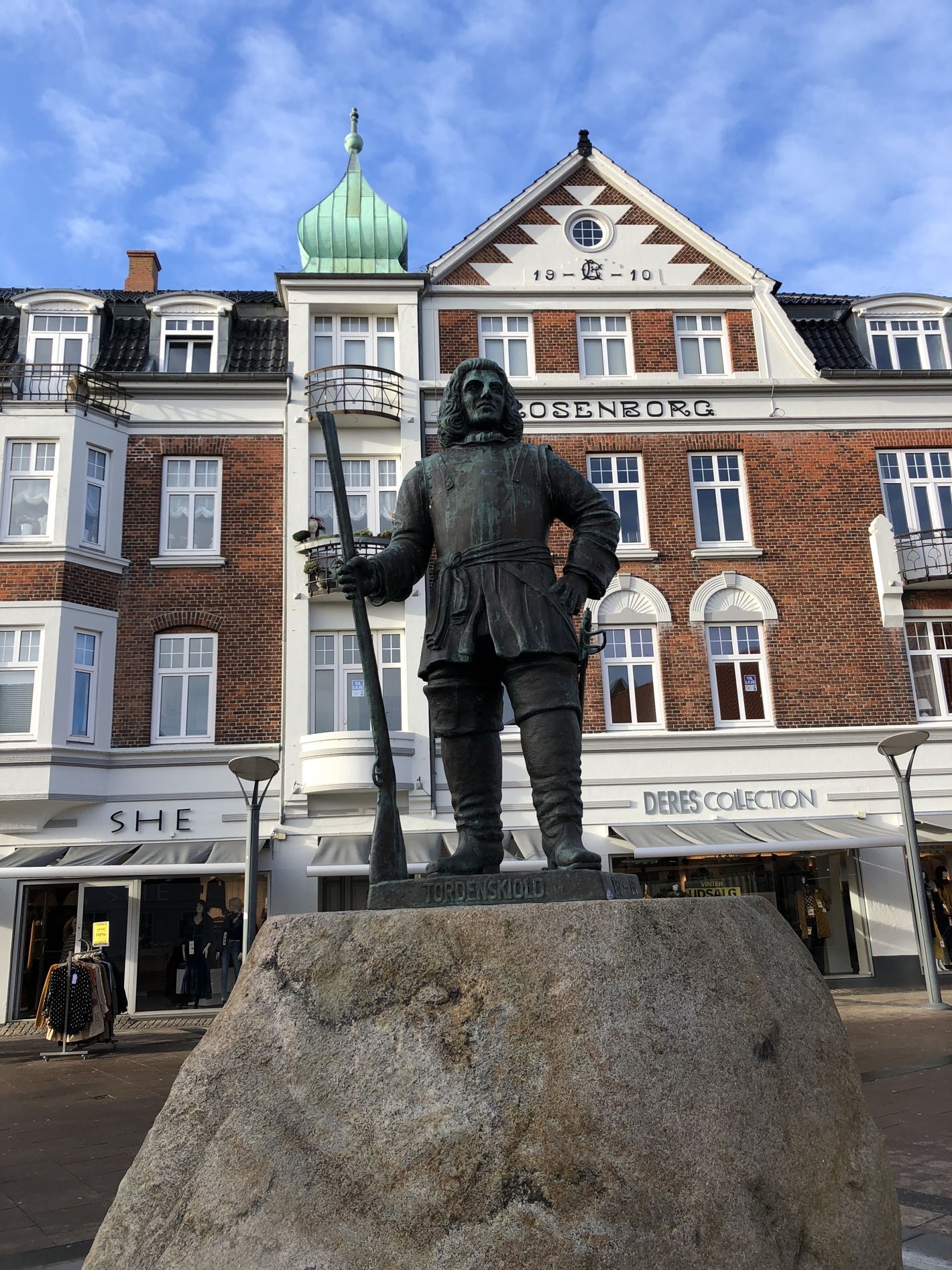 Bronzestatue af Tordenskjold med gevær på granitsokkel