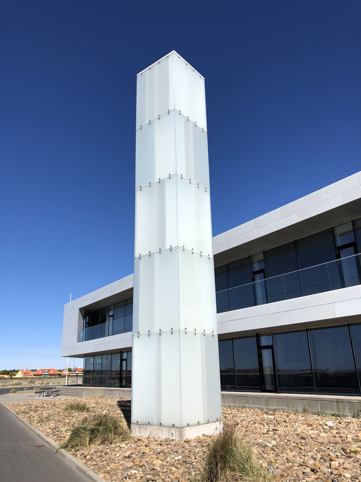 Højt firkantet tårn med glasbeklædning