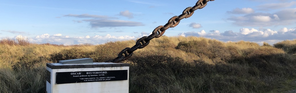 Hvid firkantet sokkel med sort kæde der stikker op i luften