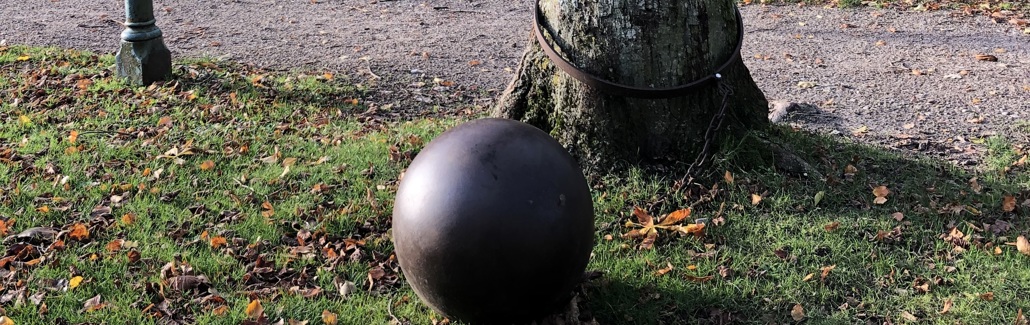 Stor jernkugle bundet fast til træ