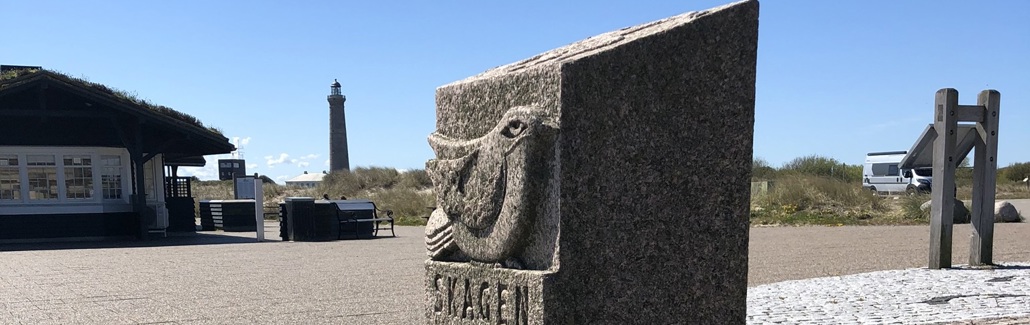 Firkantet granitsten med fuglefigur i toppen og fiskefigur i bunden