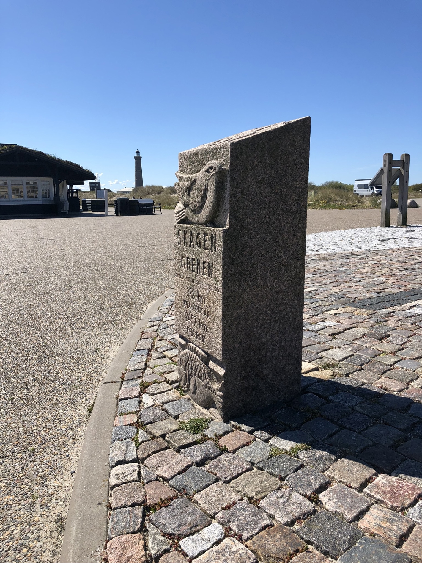 Firkantet granitsten med fuglefigur i toppen og fiskefigur i bunden