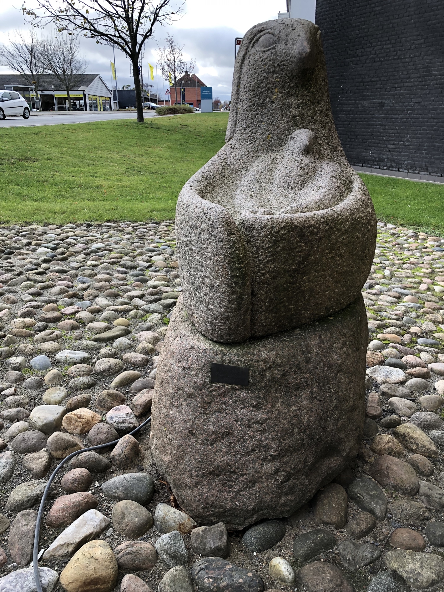 Granitskulptur af høne med sin kylling