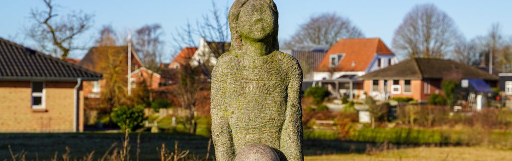 Pige med bold i hænderne i granit