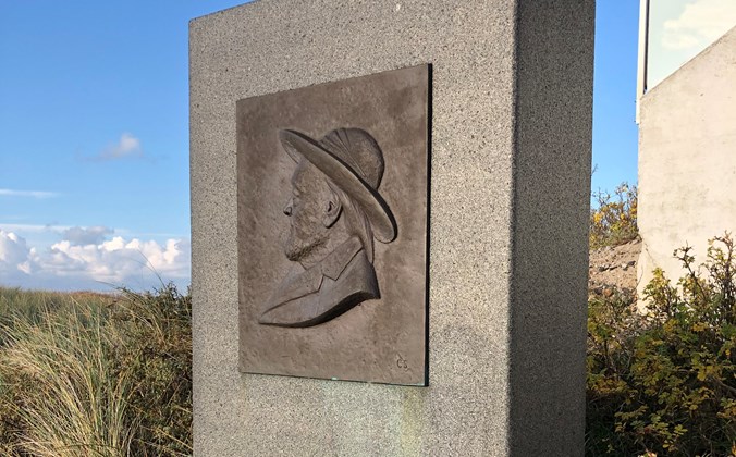 Firkantet granitsten med billede af mand med hat