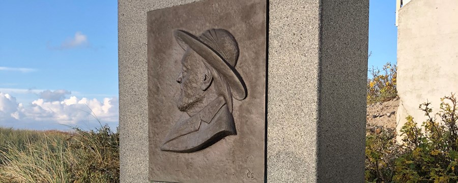 Firkantet granitsten med billede af mand med hat
