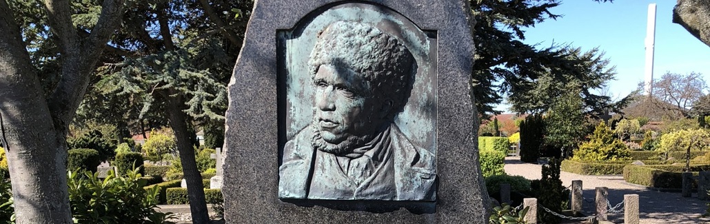 Høj mindesten med båd, ror og fugl