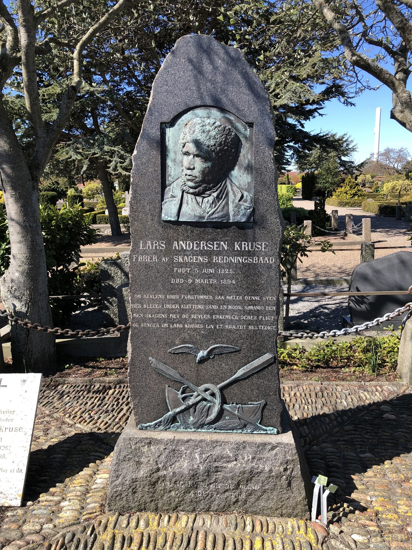 Høj mindesten med båd, ror og fugl