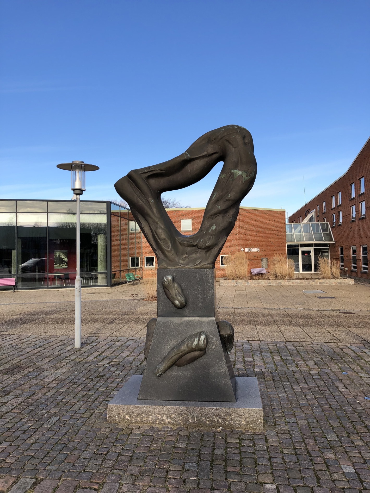 Trekantet skulptur med organiske former på sokkel