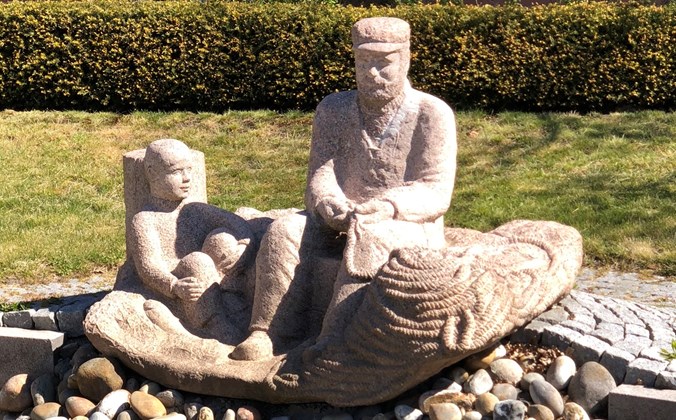 Granitskulptur af en fisker og en dreng