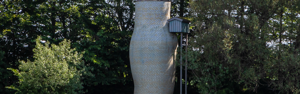 Høj lys krukke med lille blåt hus på siden