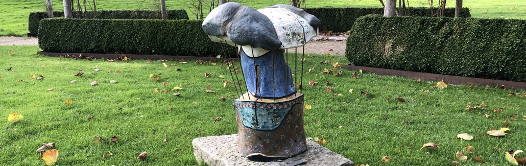 Farverig skulptur på sokkel af granit